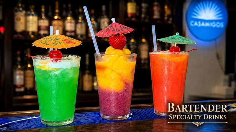 Three bartender specialty drinks with cocktail umbrellas