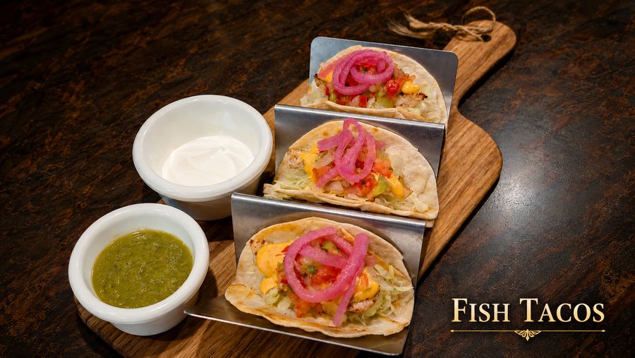 Three catch of the day fish tacos with pickled onion and salsa