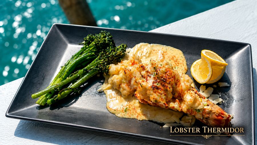 Lobster Thermidor stuffed in the shell with grilled broccolini over the harbour