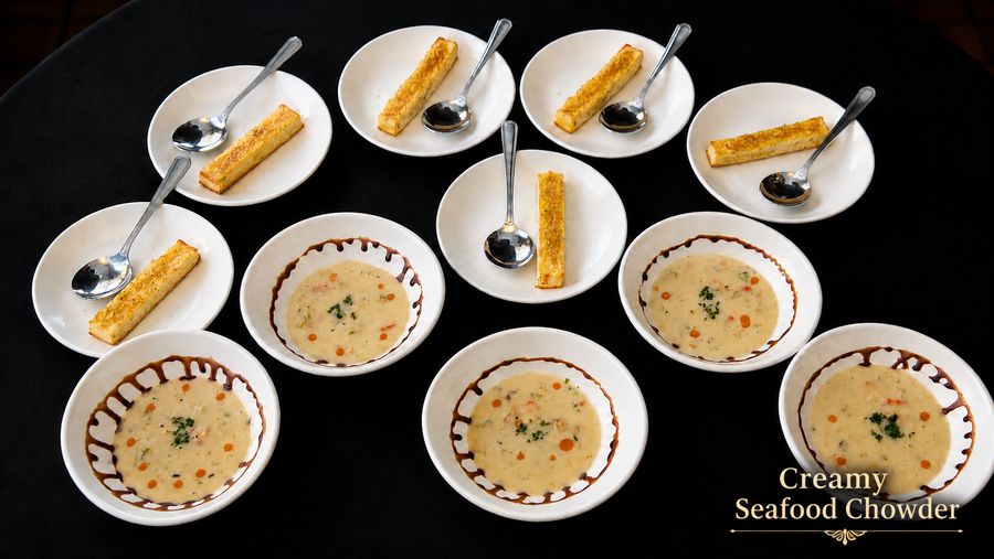Bowls of creamy seafood chowder with garlic toast